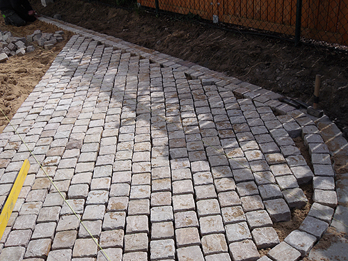 Hier macht der Weg eine Kurve Pflasterung eines Gartenwegs