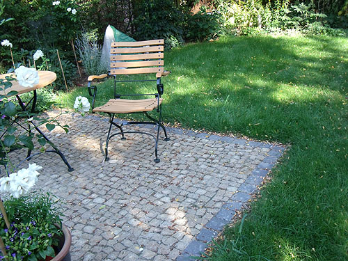 Der Sitzplatz ist in die Rasenfläche integriert Gepflasterter Sitzplatz