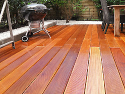 Bangkirai-Holzterrasse mit einer Einfassung aus Kiesel