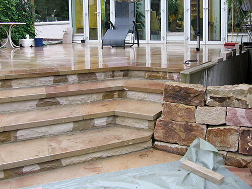 Terrasse mit Treppe und Natursteinmauer